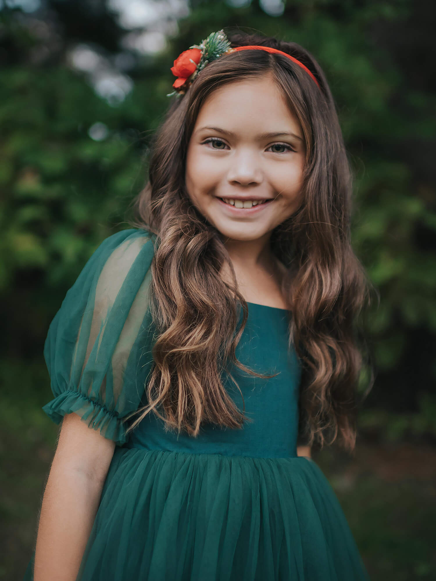 A young girl wears our emerald green tulle Gabrielle Christmas dress.