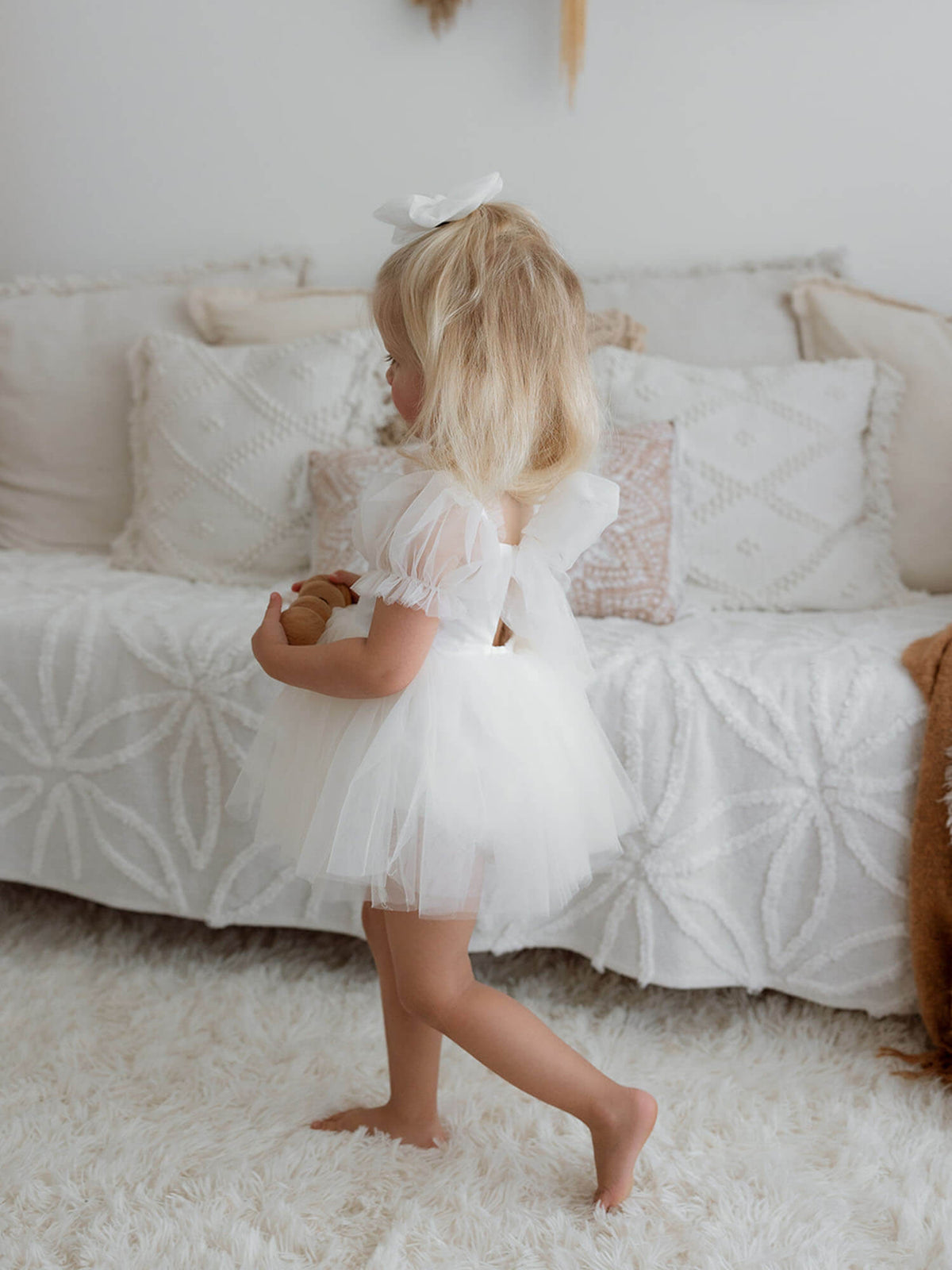 Toddler in our Gabrielle cream flower girl romper with tulle detailing.