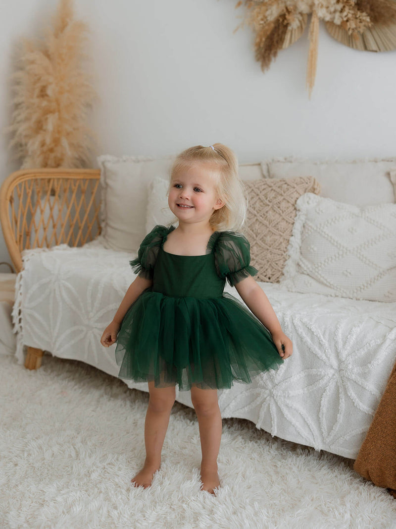 Gabrielle emerald green baby flower girl romper is worn by a toddler.