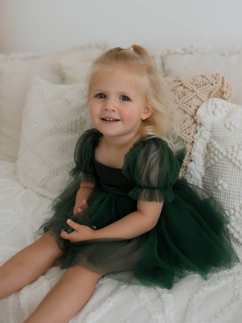 Gabrielle green baby flower girl dress romper is worn by a toddler.