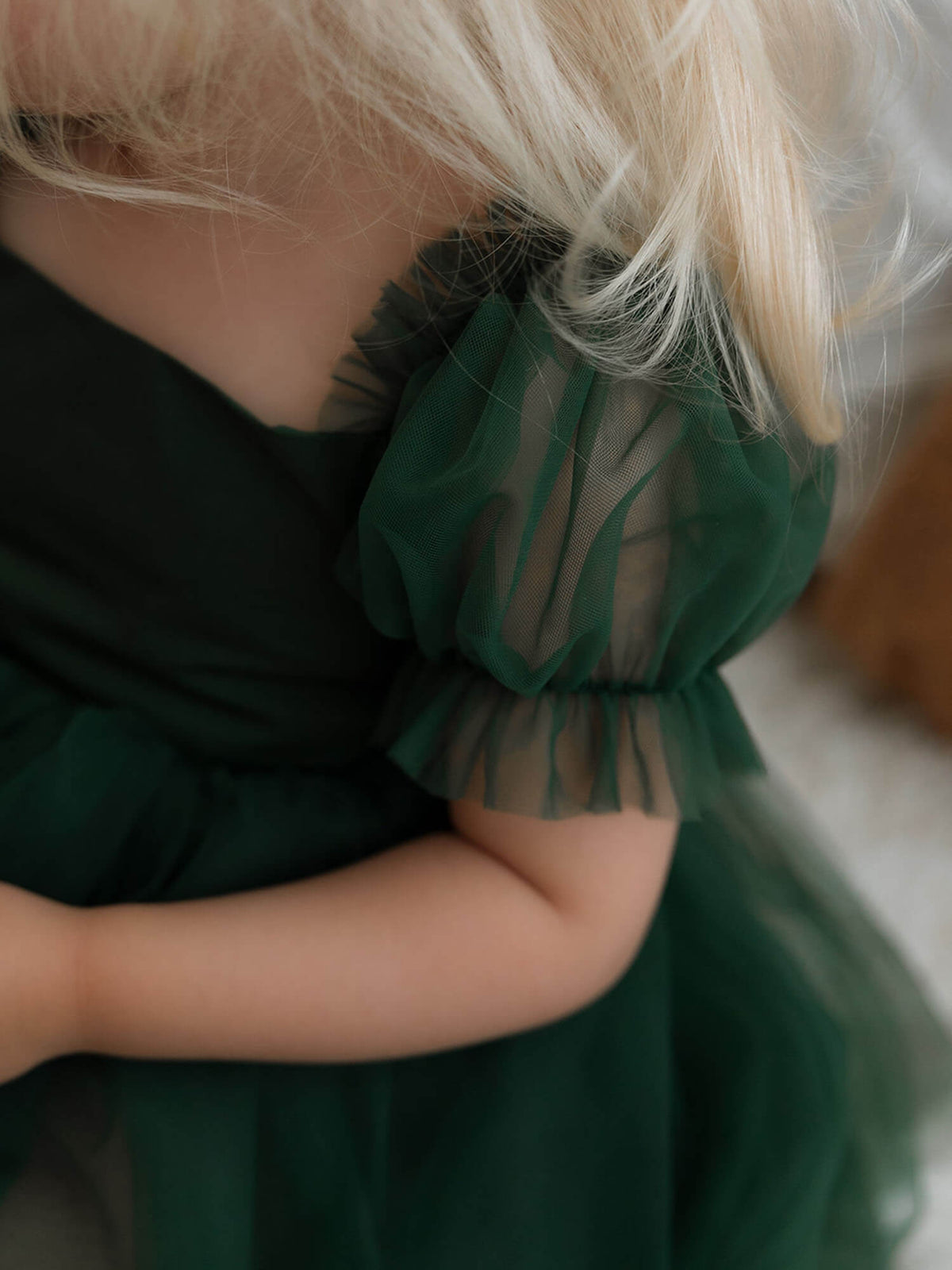 The soft tulle puff sleeve of our Gabrielle baby flower girl romper dress in emerald green.