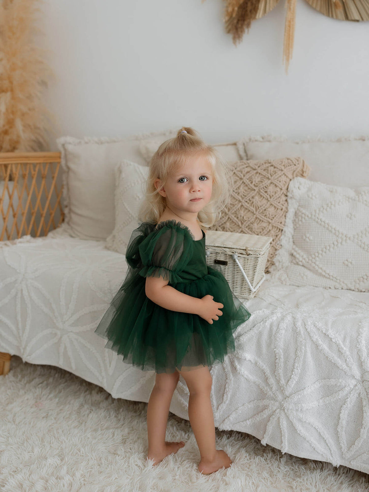 Emerald green baby flower girl dress is worn by a young girl.