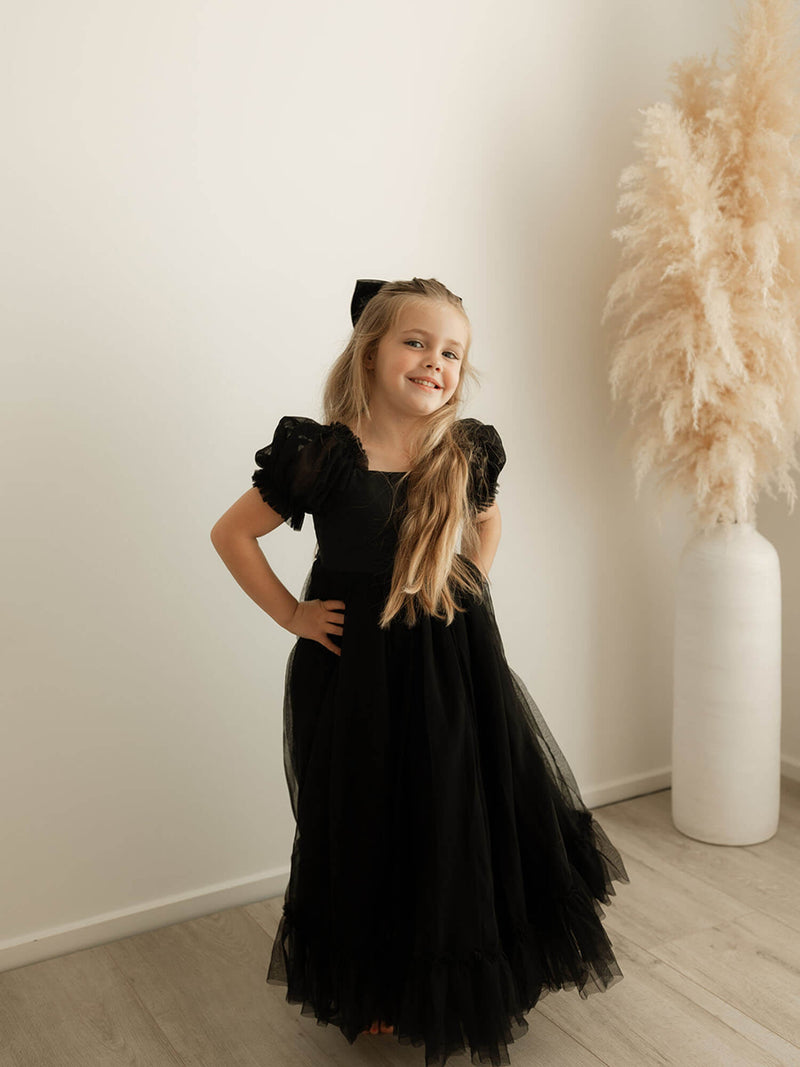 Our Gabrielle full length black girls dress is worn by a young girl.