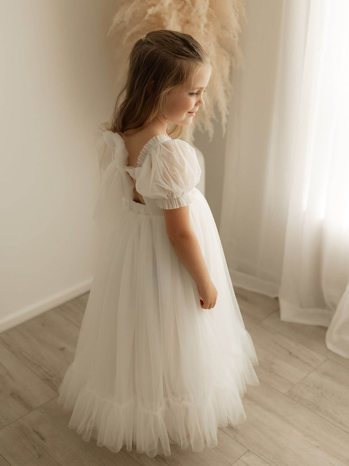 The back of the Gabrielle full length ivory tulle flower girl dress, showing the tulle bow detail at the back.