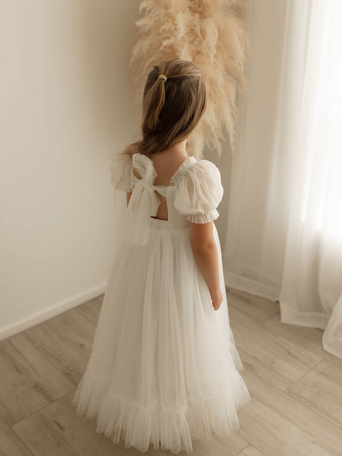 The back of the Gabrielle full length dress in ivory with back bow detail.