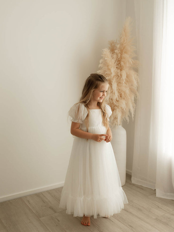 Gabrielle tulle flower girl dress in full length is worn by a young girl. Showing the full length tulle prairie skirt.