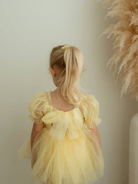 The back of our Gabrielle lemon yellow baby flower girl romper, showing the tulle back bow.