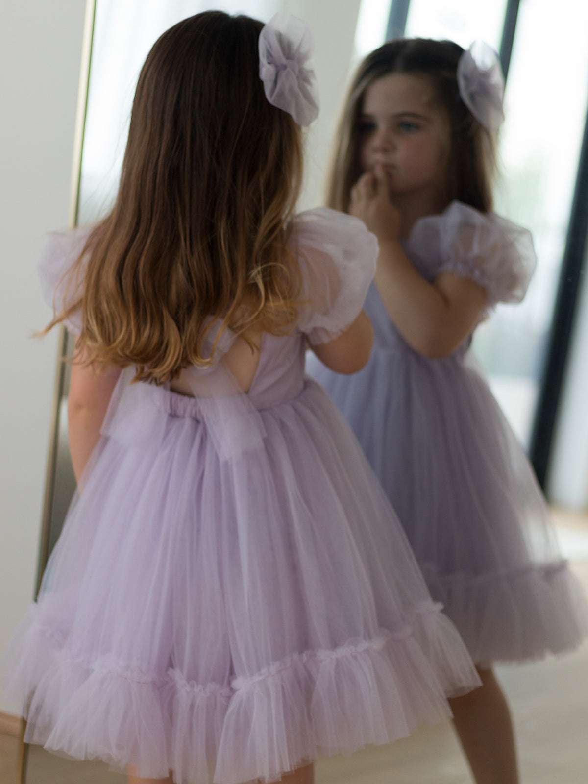 The back of the lilac purple Gabrielle flower girl dress, also showing the matching lilac tulle bow.