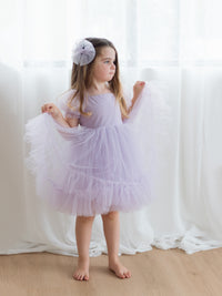 A little girl wears our Gabrielle lilac purple tulle flower girl dress.