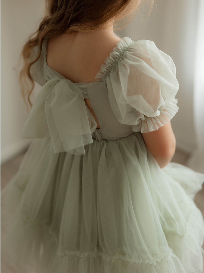 The back detail of our Gabrielle sage flower girl dress, showing the tulle bow at the back and tulle puff sleeves.