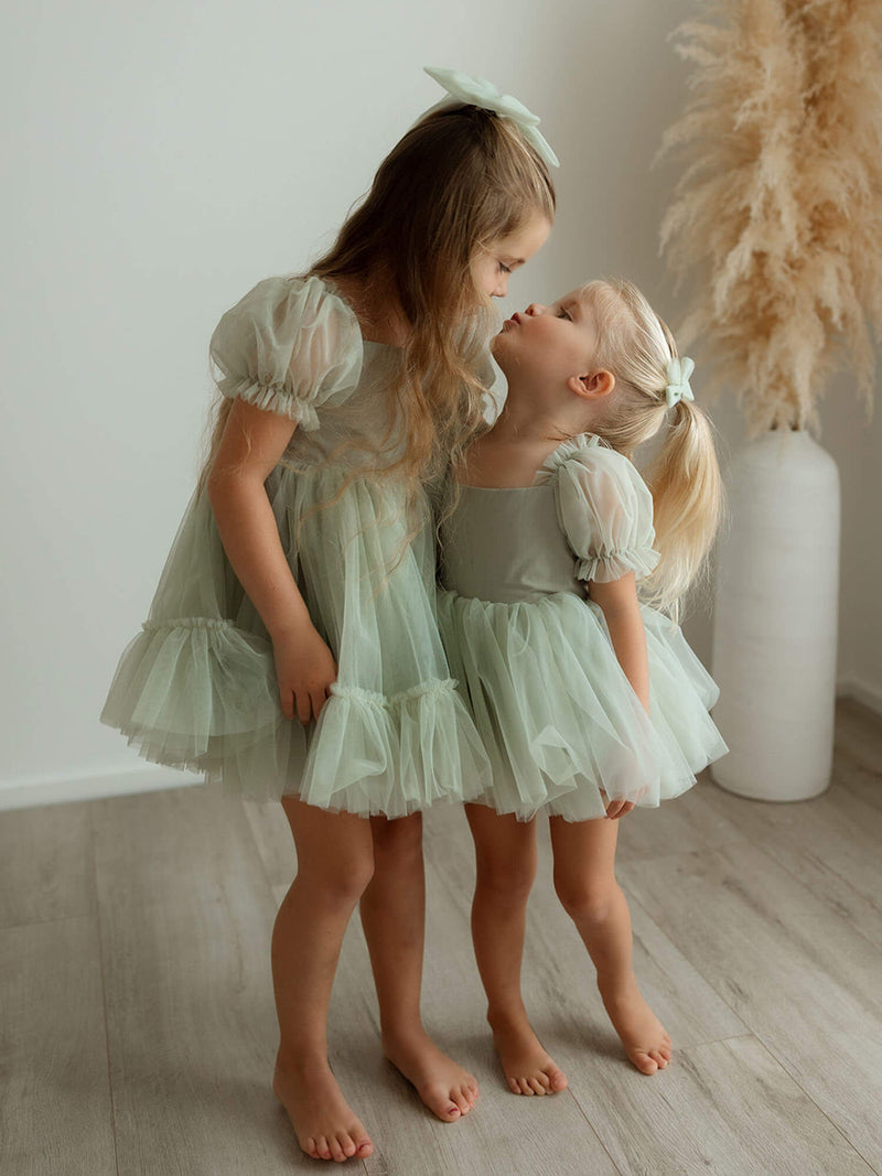 Sisters wear matching Gabrielle sage green flower girl dress and Gabrielle sage green baby flower girl romper.