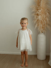 Child wears our Gia ivory flower girl romper.