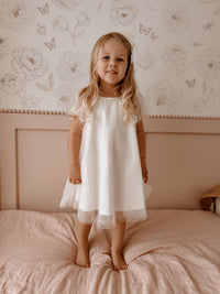 A little girl wears our Gia flower girl dress in flocked confetti tulle.