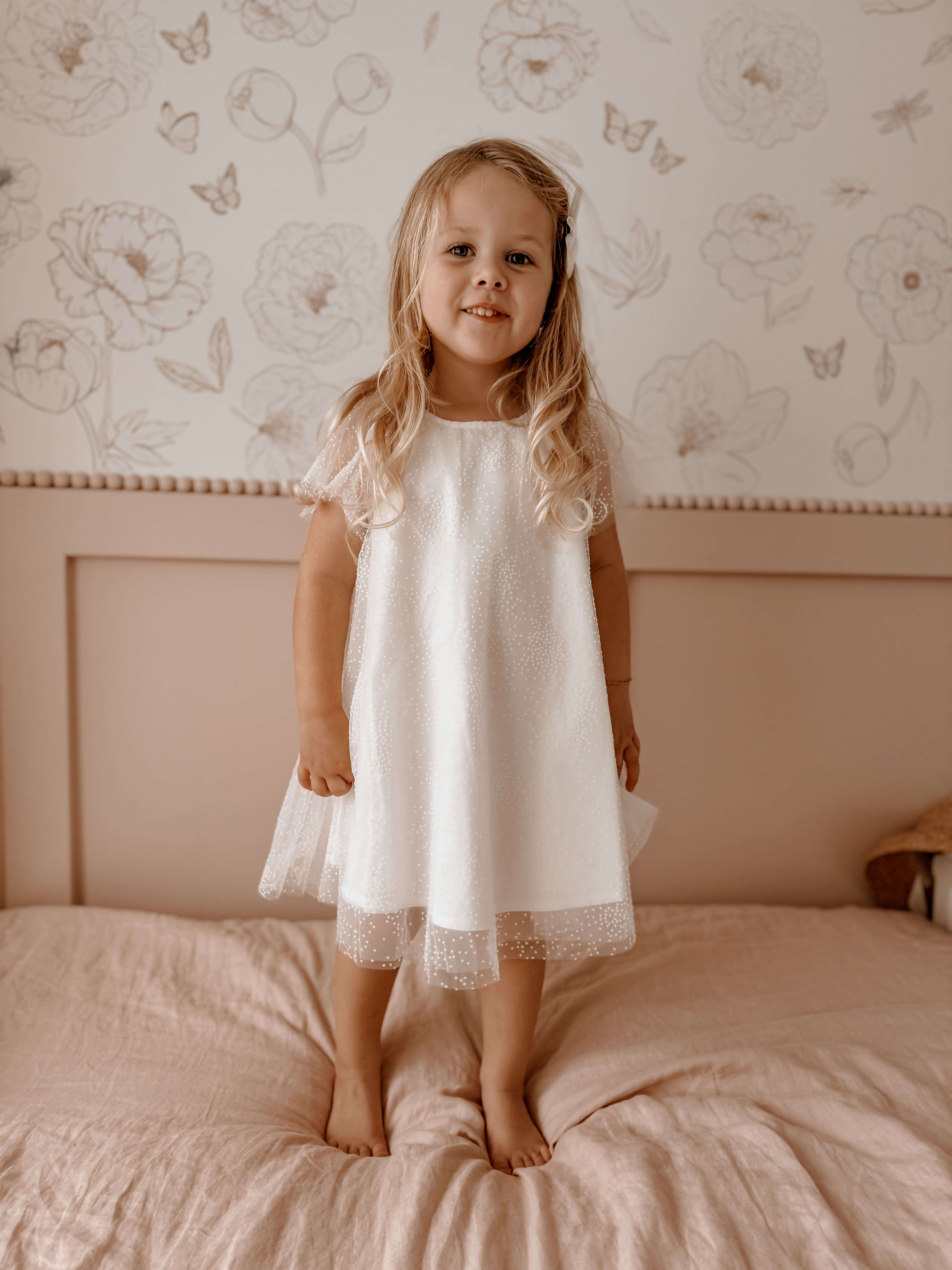 A little girl wears our Gia flower girl dress in flocked confetti tulle.