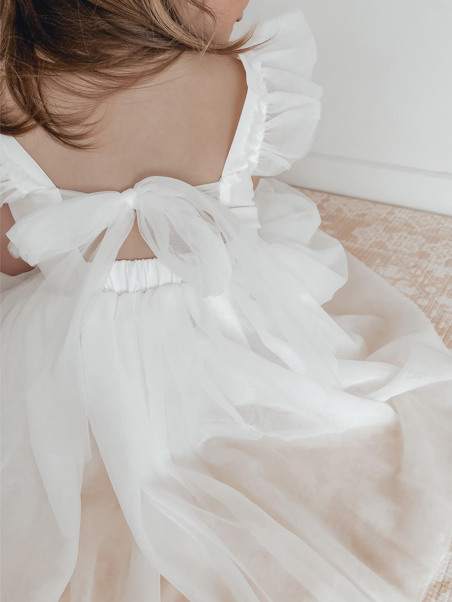 Gigi flower girl dress is shown from the back, showing the tulle bow at the back of the dress.