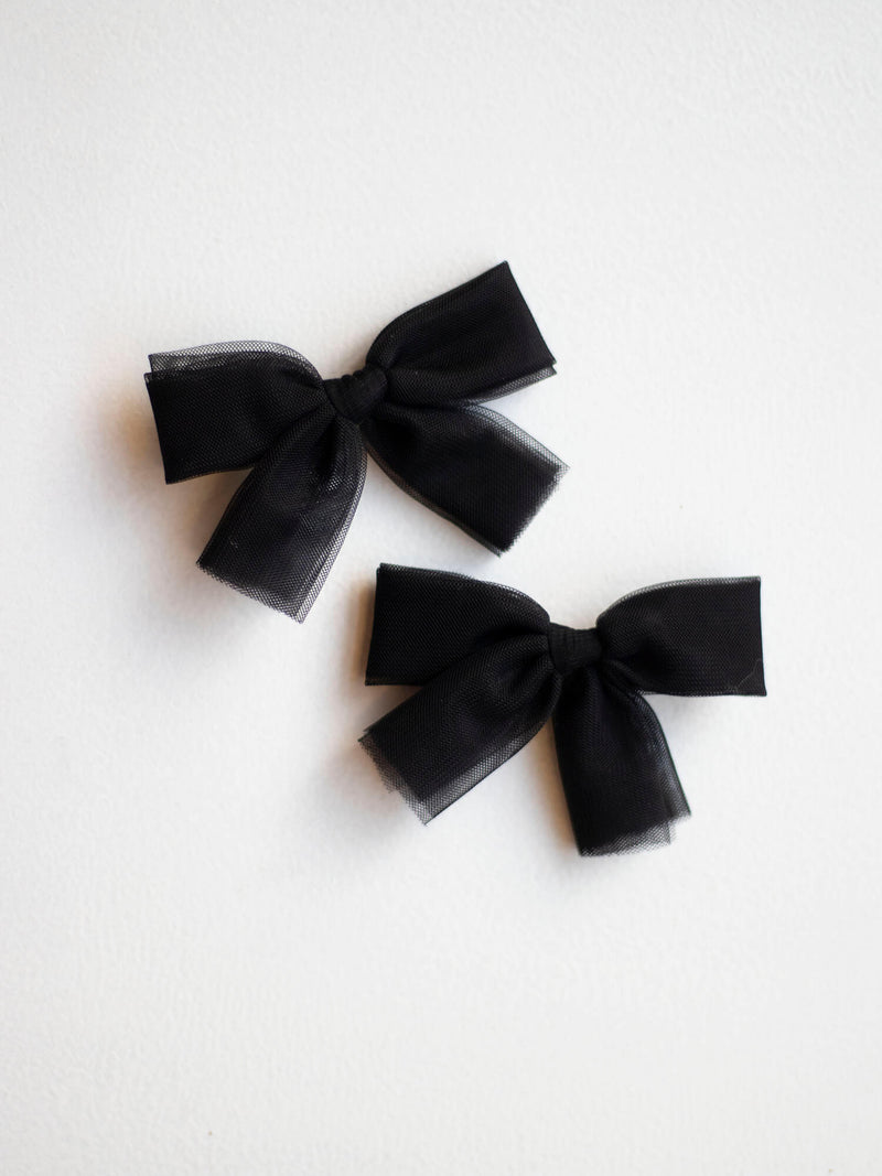 Small pigtail black tulle bows.