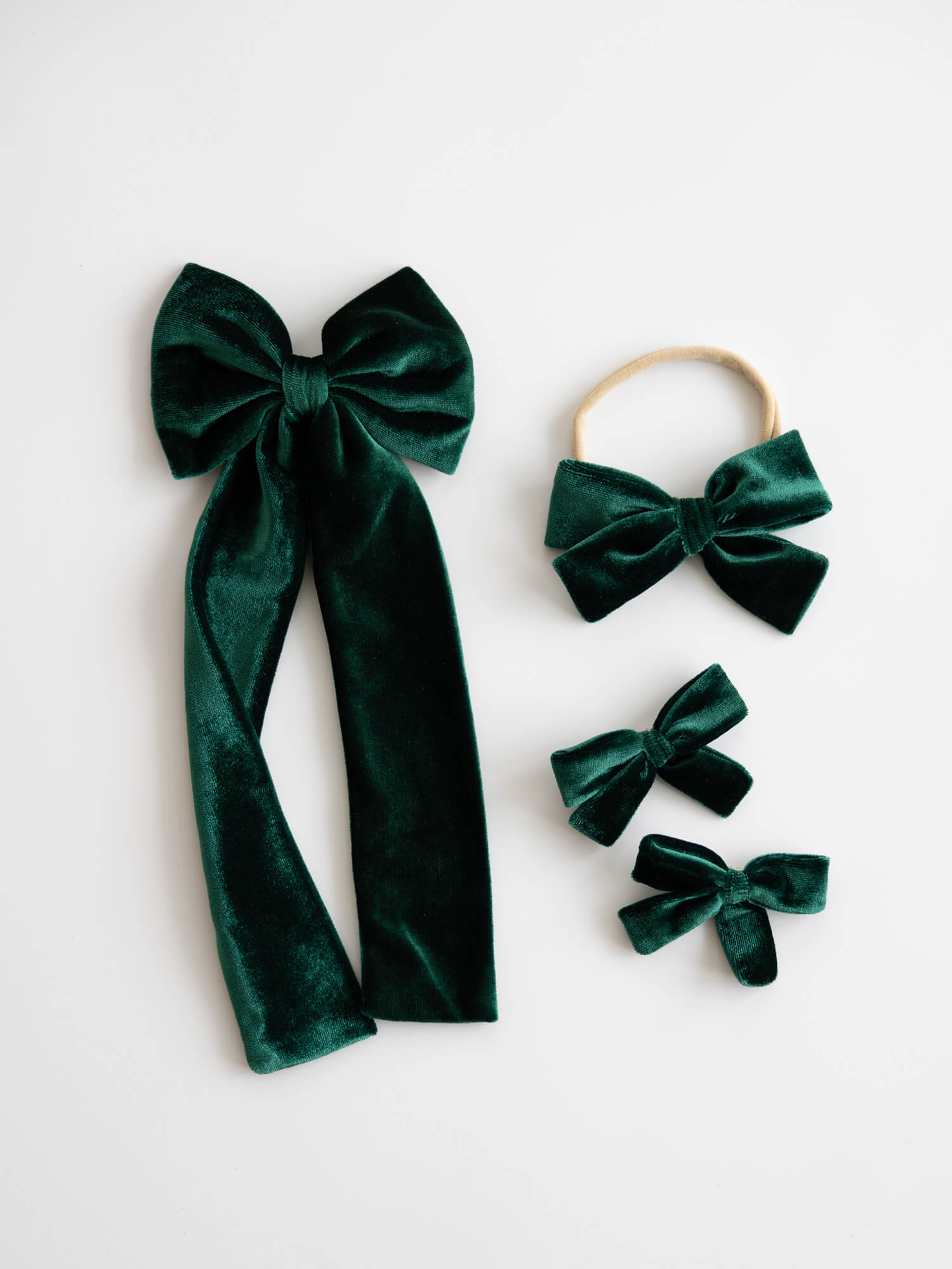 Set of green velvet hair bows on a white background