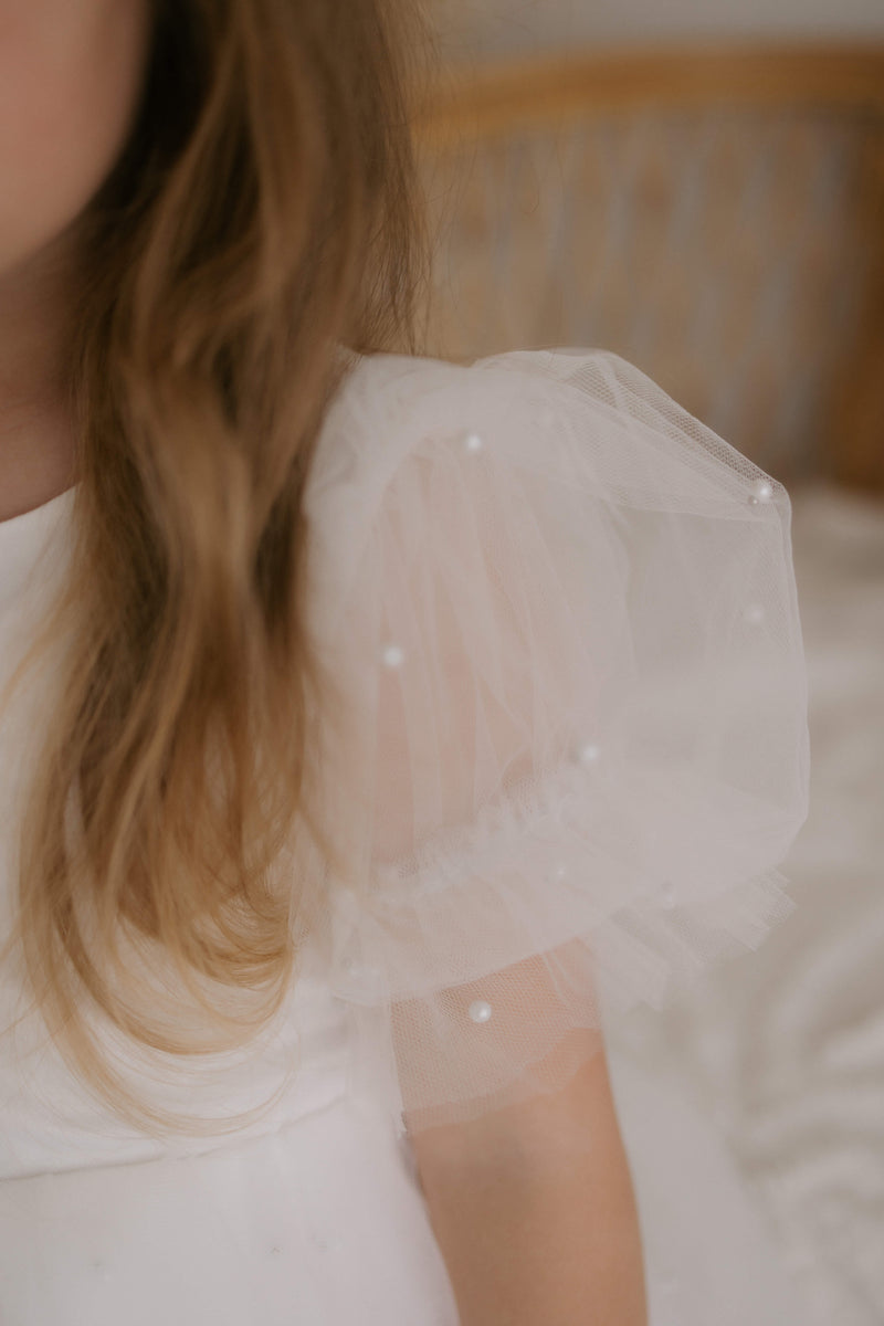 Close view of the beading on the tulle puff sleeves of our Gracie flower girl dress.