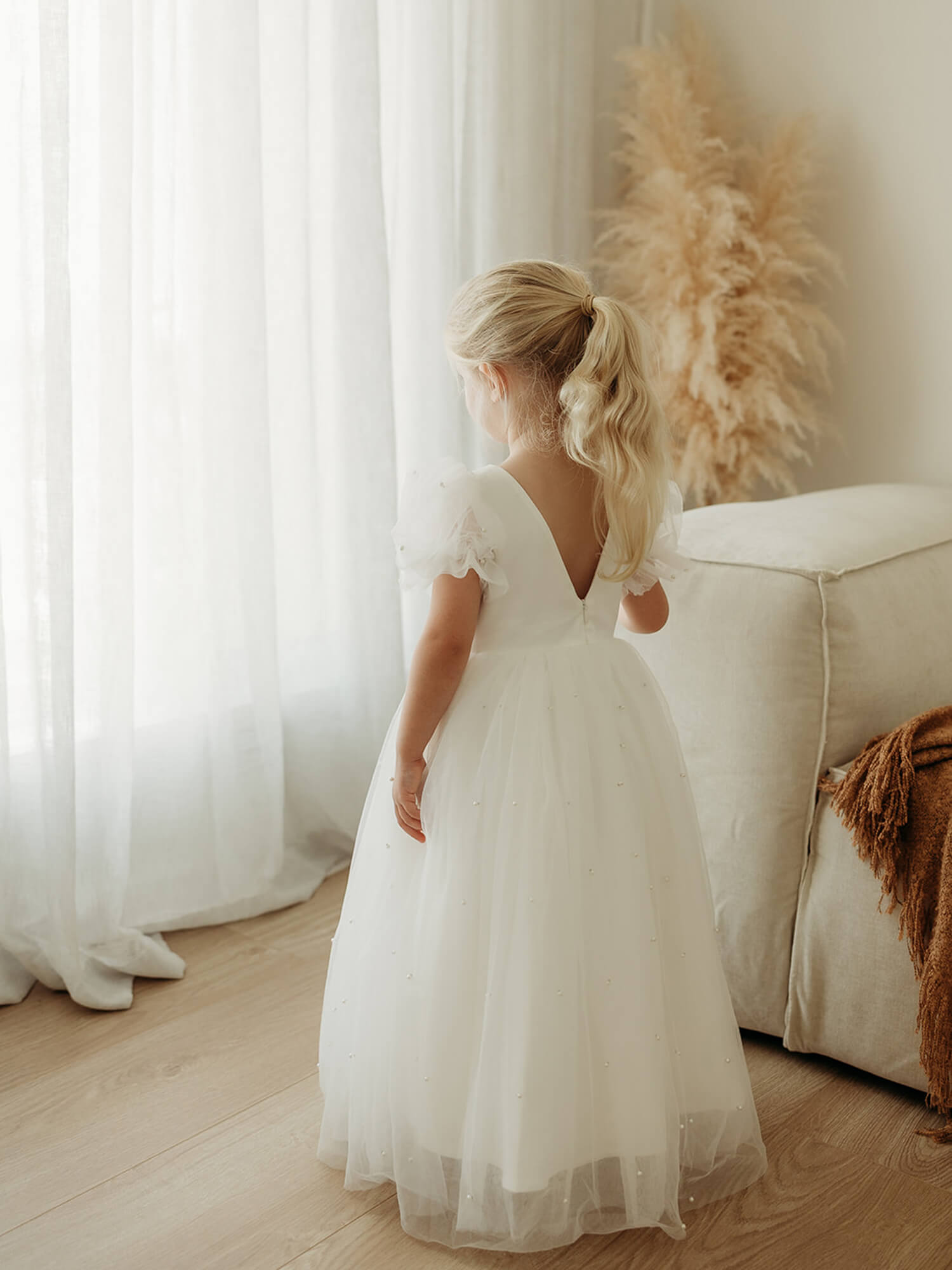 The back of our Gracie full length pearl bead flower girl dress, showing the V back and tulle puff sleeves.