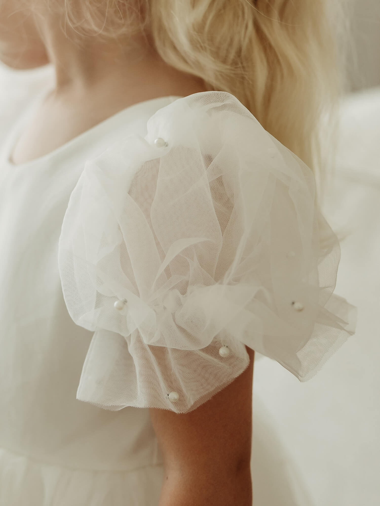 The tulle puff sleeve detail with pearl beads on our Gracie flower girl dress.