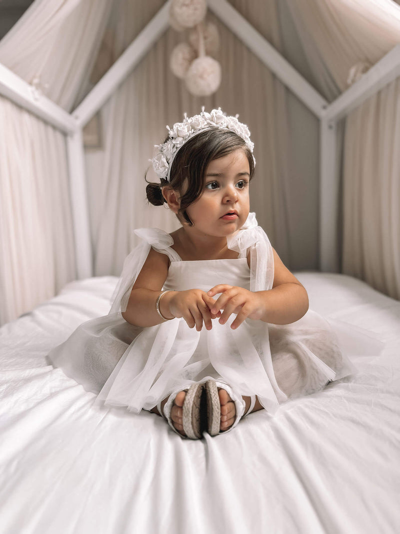Harper white baby flower girl romper is worn by a toddler, showing the tulle tie straps and soft tulle skirt.