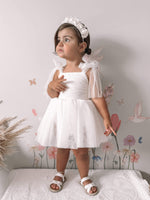 Harper baby flower girl romper is worn by a toddler, she also wears a white floral headband.