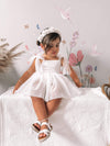 Harper ivory baby flower girl romper dress is worn by a young girl.