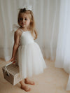 Harper tea length flower girl dress in cream is worn by a girl carrying a basket.
