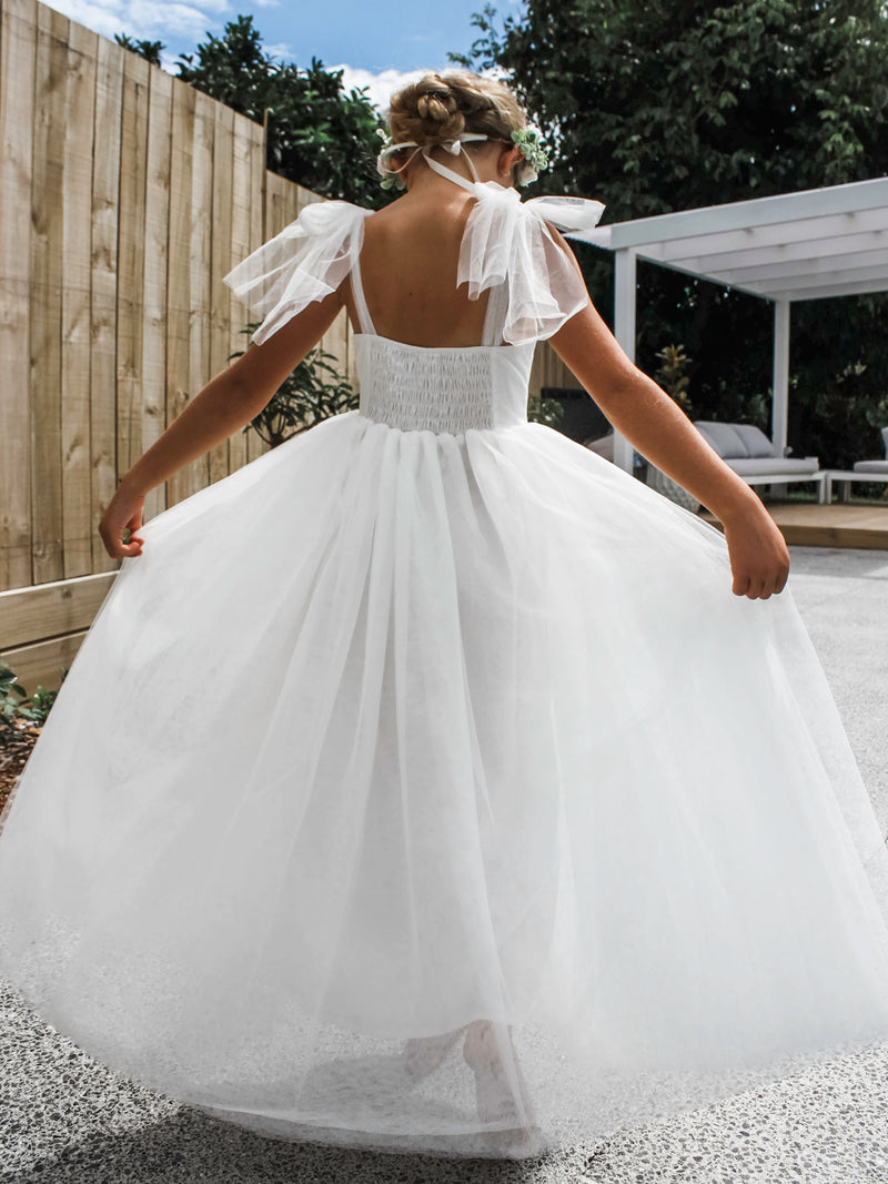 Soft tulle Harper flower girl dress worn by a young model. Beautiful tulle girls dress for a special occasion.