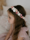Close view of our Elsie girls flower crown in dusty rose, matched with our Harper flower girl dress, worn by a young girl.