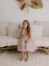 A little girl sits wearing our Elsie flower crown and dusty pink Harper tea length flower girl dress.