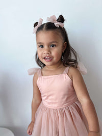 Our Isla toddler flower girl dress with built in romper is worn by a young girl, she also wears matching tulle bows in her hair.