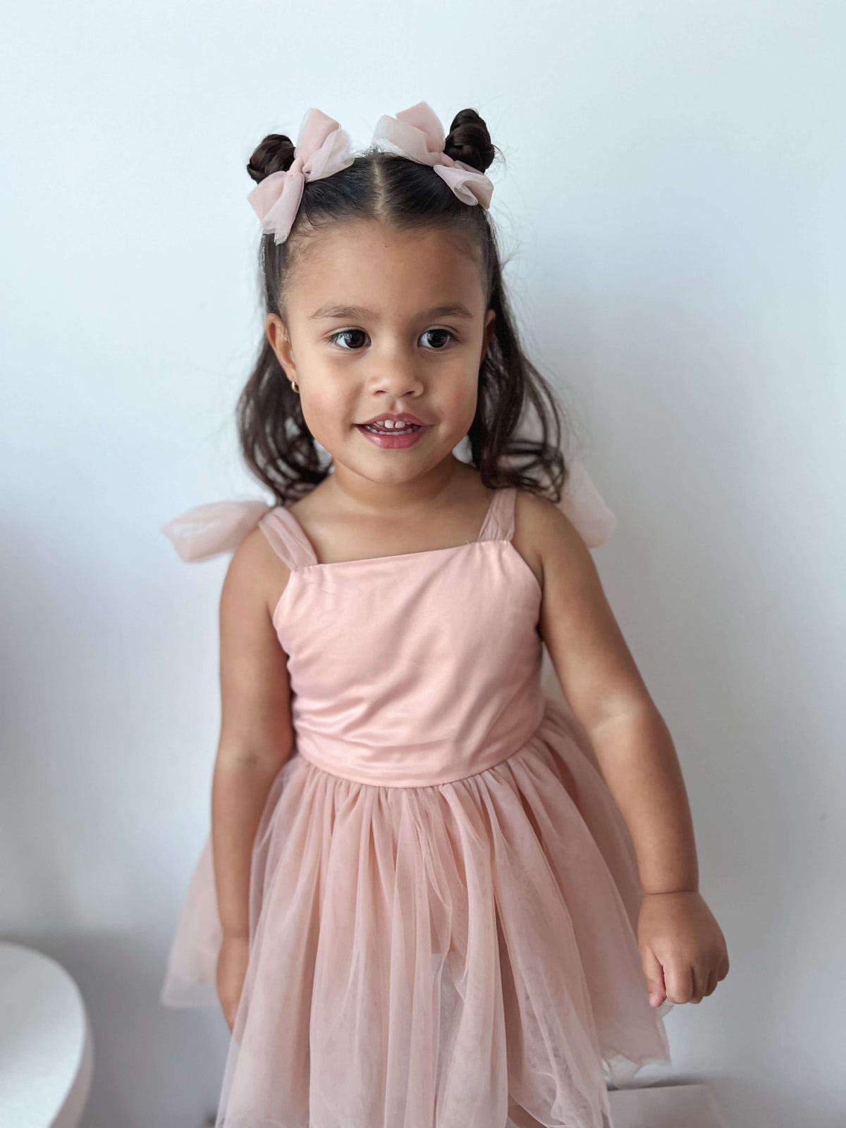 Our champagne Isla baby flower girl dress with built in romper is worn by a young girl.