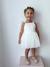 A young toddler wears our ivory Isla toddler flower girl dress and Elsie girls ivory flower crown.