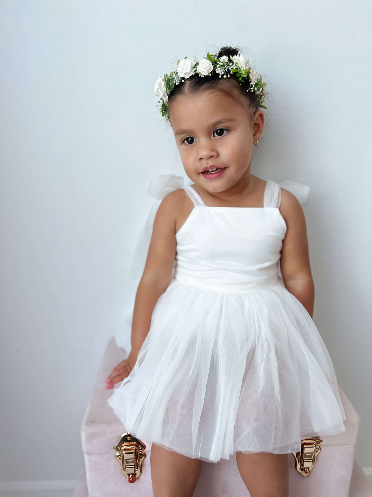 A young girl wears our Isla ivory flower girl romper and Elsie ivory flower crown.