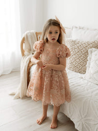 Kenzi dusty rose flower girl dress is worn by a young girl.