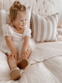 Toddler wears our Layla baby flower girl romper dress in ivory.