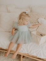 Layla baby flower girl dress in dusty blue is worn by a young girl.