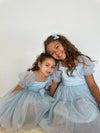 Flower girls wear our dusty blue Layla flower girl dress and matching blue bows in their hair.