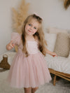 Dusty pink Layla flower girl dress is worn by a young girl.