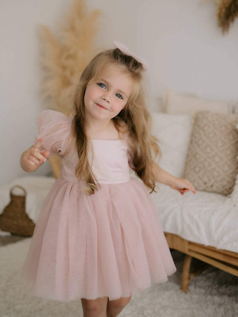 Dusty pink Layla flower girl dress is worn by a young girl.