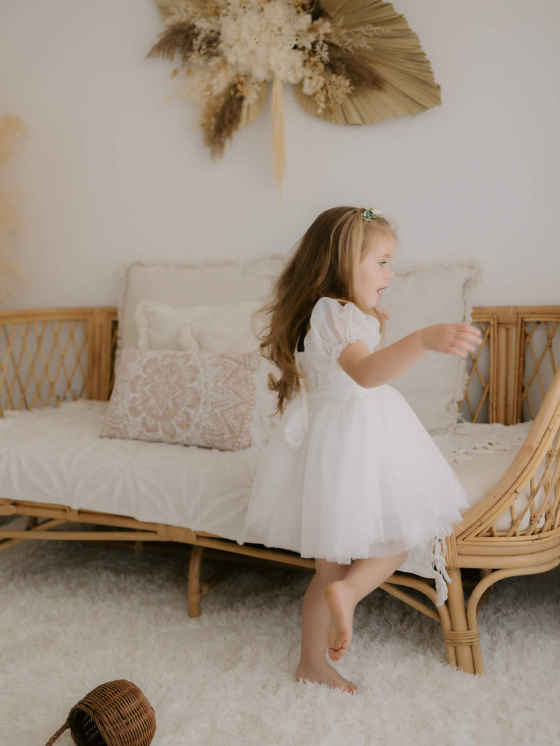 Our Layla flower girl dress is worn by a young girl who is twirling.