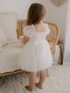 The back of our Layla puff sleeve flower girl dress in ivory, showing the tulle bow at the back.