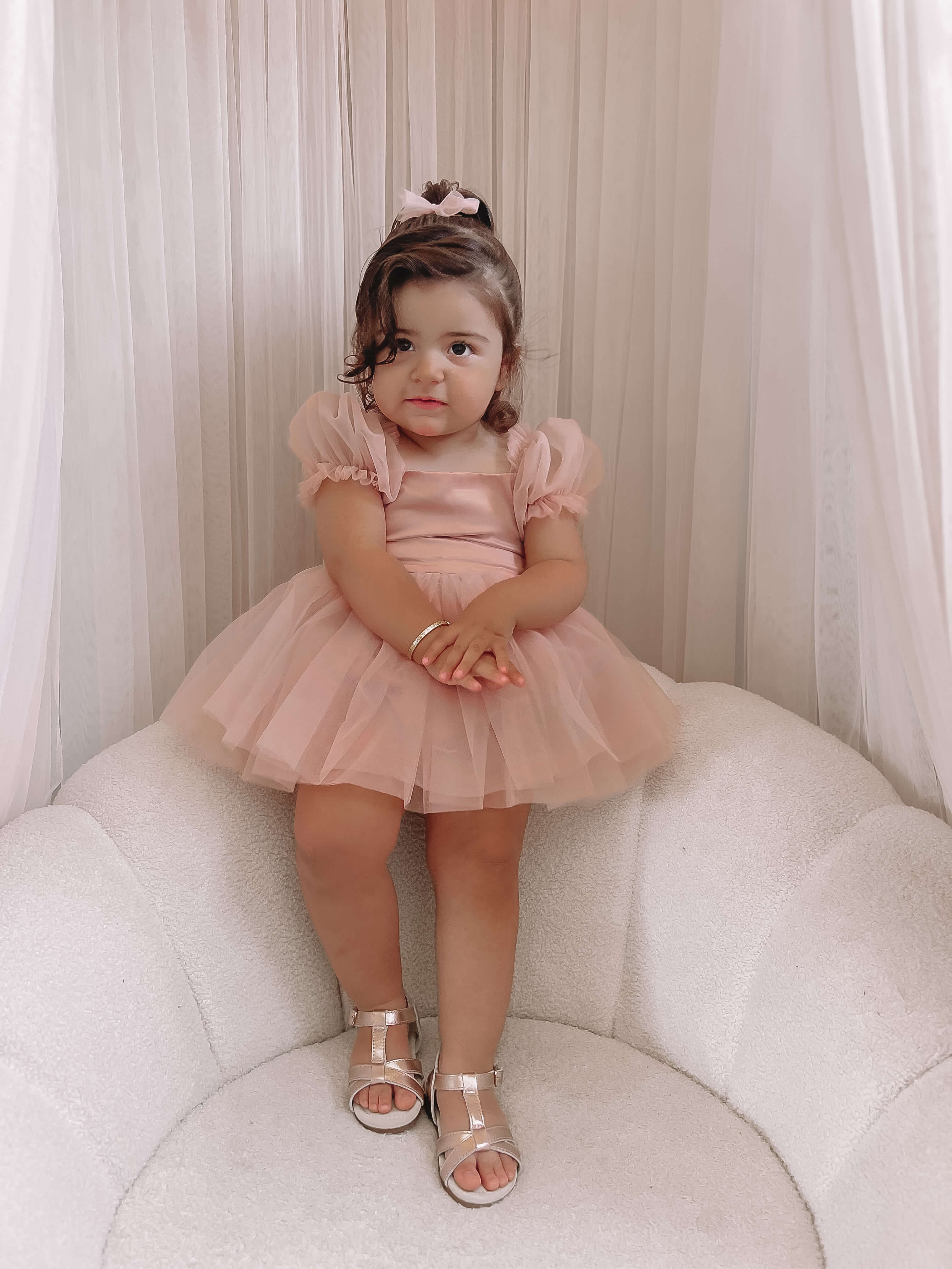 Layla toddler flower girl dress in champagne is worn by a toddler.
