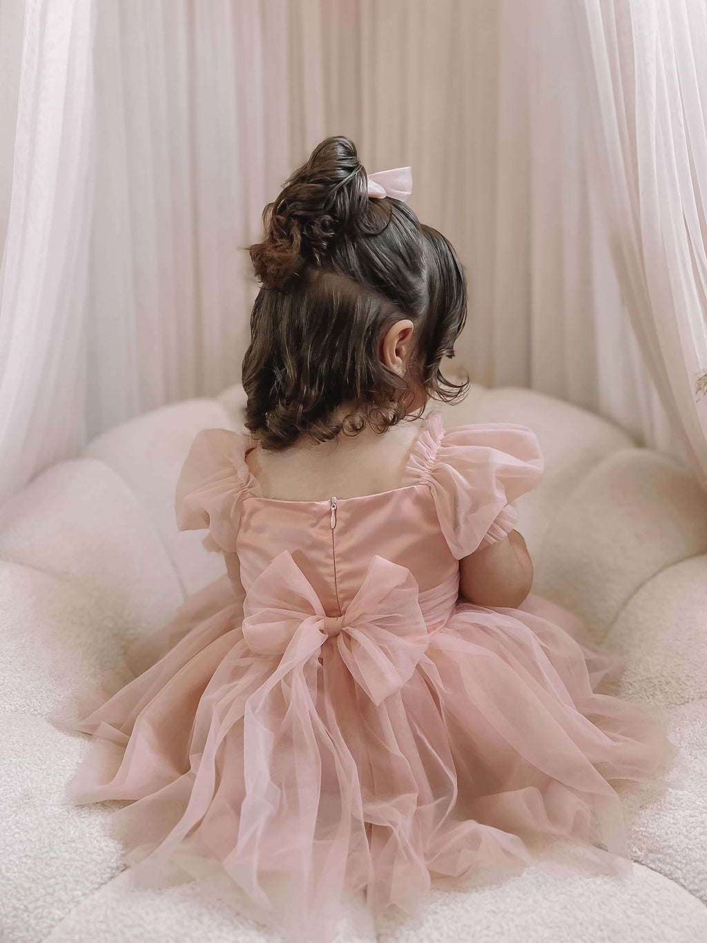 Layla toddler flower girl dress in champagne is worn by a toddler.