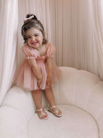 Champagne toddler flower girl dress is worn by a young girl, she also wears a tulle bow hair clip.