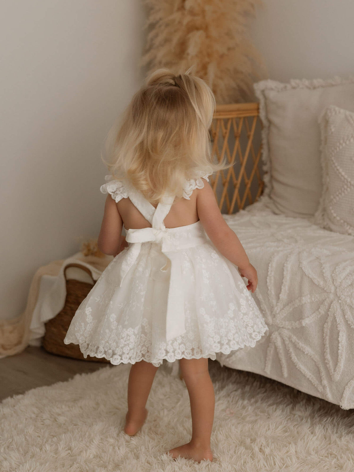 The back of our Loulou ivory lace toddler flower girl dress, showing the bow tied at the back.