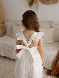 The back of our Loulou lace flower girl dress, showing the flutter sleeves tied into a large bow at the back.