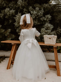 Lucy winter flower girl dress shown on a flower girl from the back. Showing the zip closure, big satin bow and full length tulle skirt.