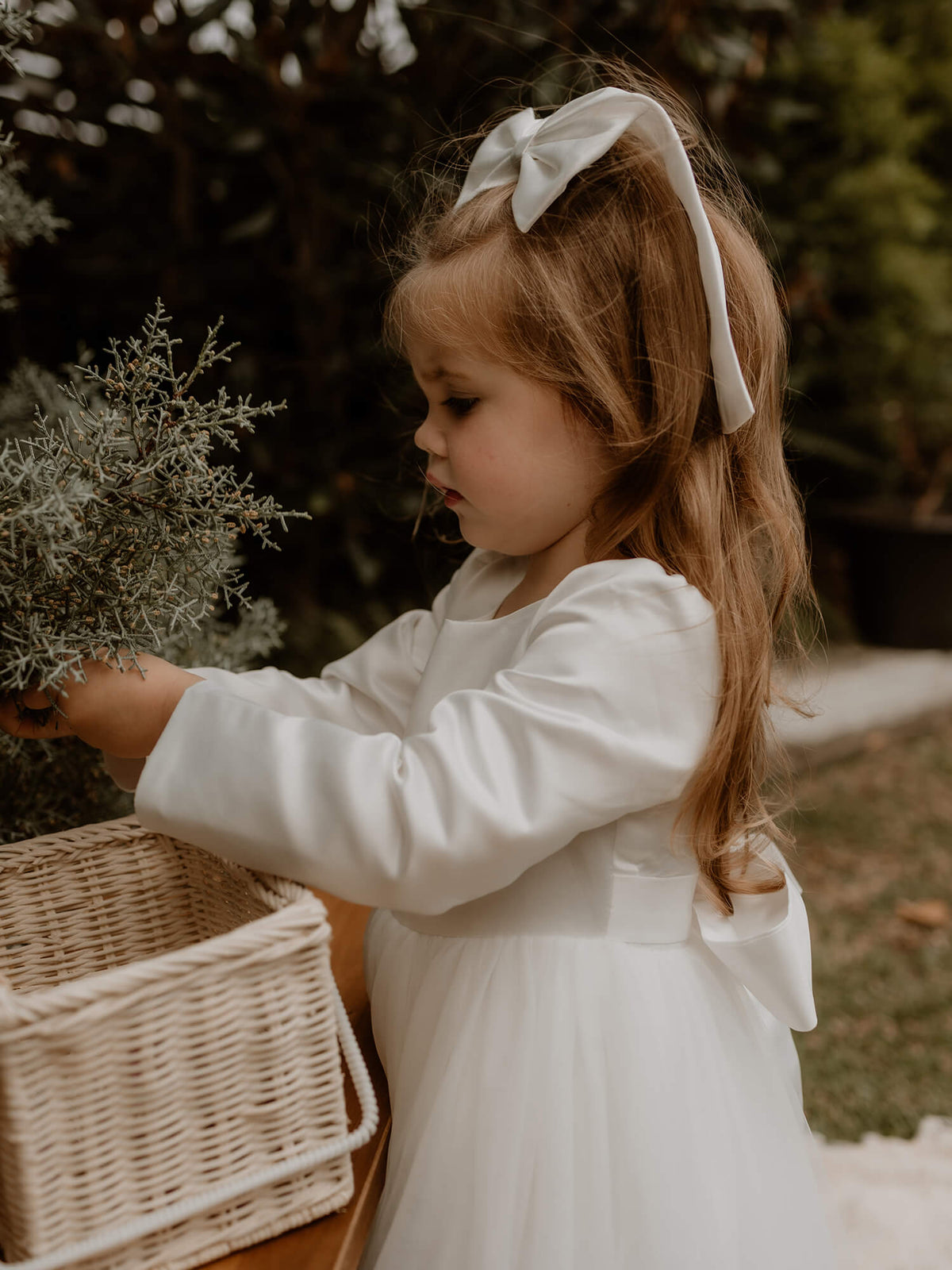 Lucy winter flower girl dress with full length satin sleeves shown close up.